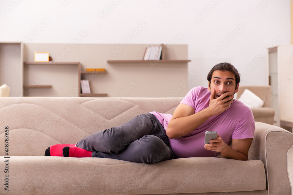 Young man watching tv at home during pandemic Young man watching tv at home during pandemic