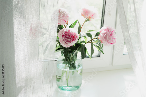 Fototapeta Naklejka Na Ścianę i Meble -  A view of a bouquet of pink peonies standing in a vase on the window. Concept background, flowers, holiday.