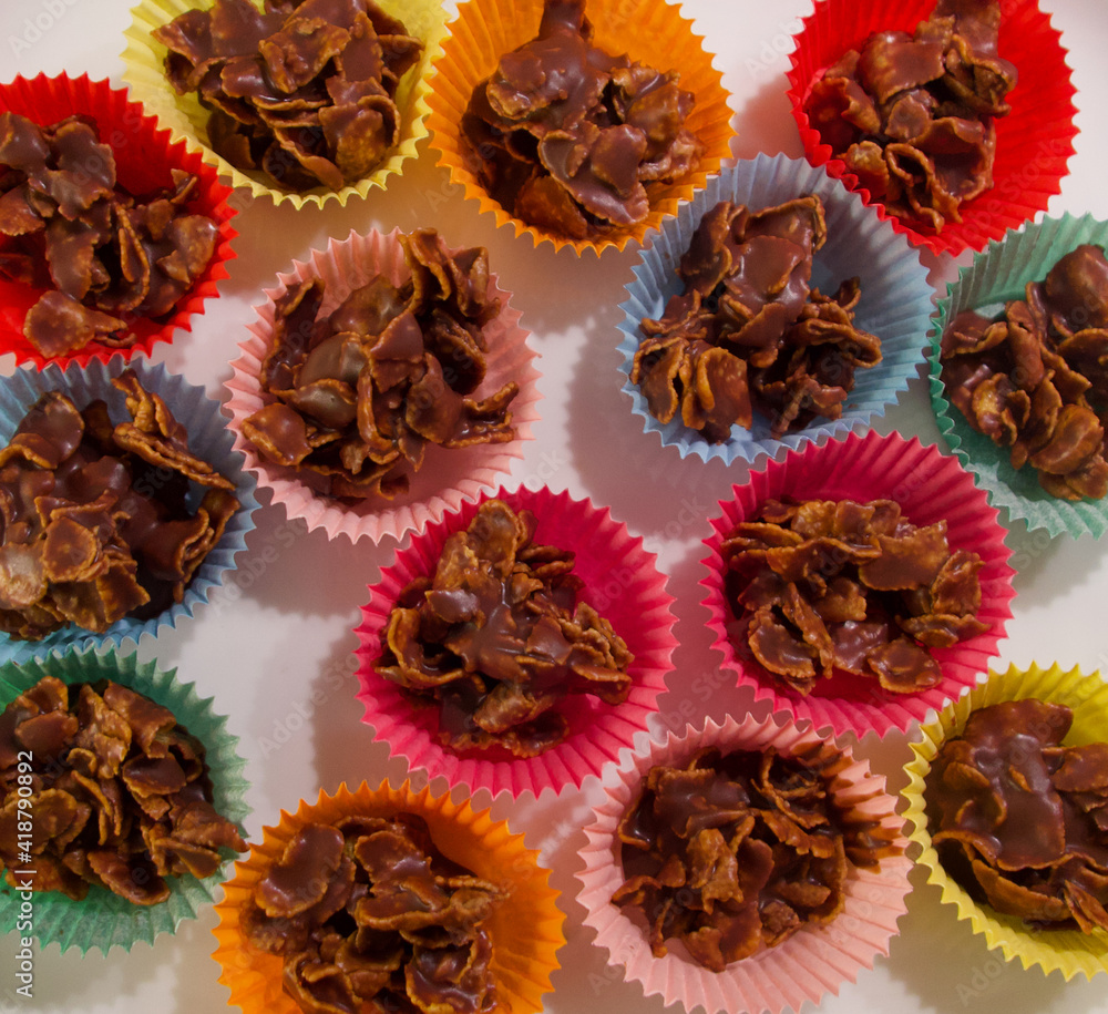 Full frame image of cornflake chocolate crispy cakes in coloured paper ...