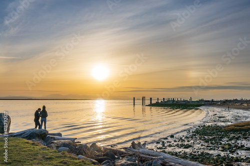 Richmond, BC, Canada - MAR 03 2021 : People enjoy the sunset scenery in Garry Point Park.
