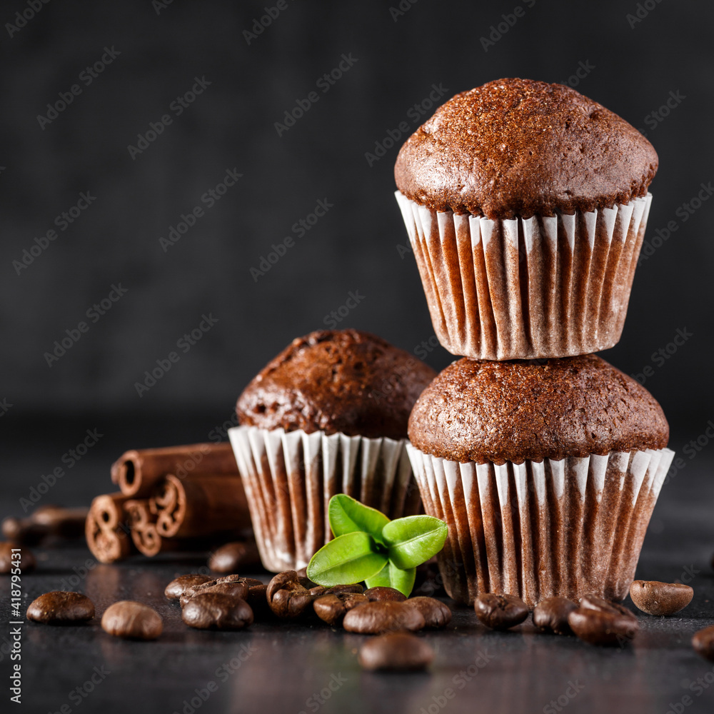 Chocolate cupcake with icing and chocolate bar in Dark lighting,Homemade delicious chocolate muffin on wooden background close-up Chocolate cupcake with icing and chocolate bar in Dark lighting,Homemade delicious chocolate muffin on wooden background close-up