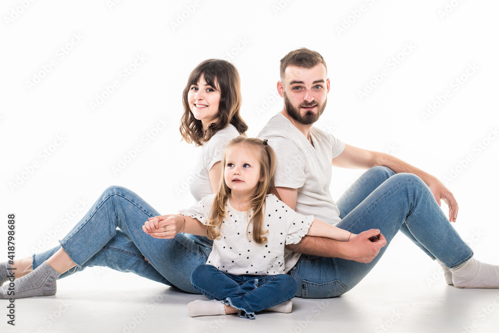 Young family with daughter sitting on the floor isolated on white background Young family with daughter sitting on the floor isolated on white background