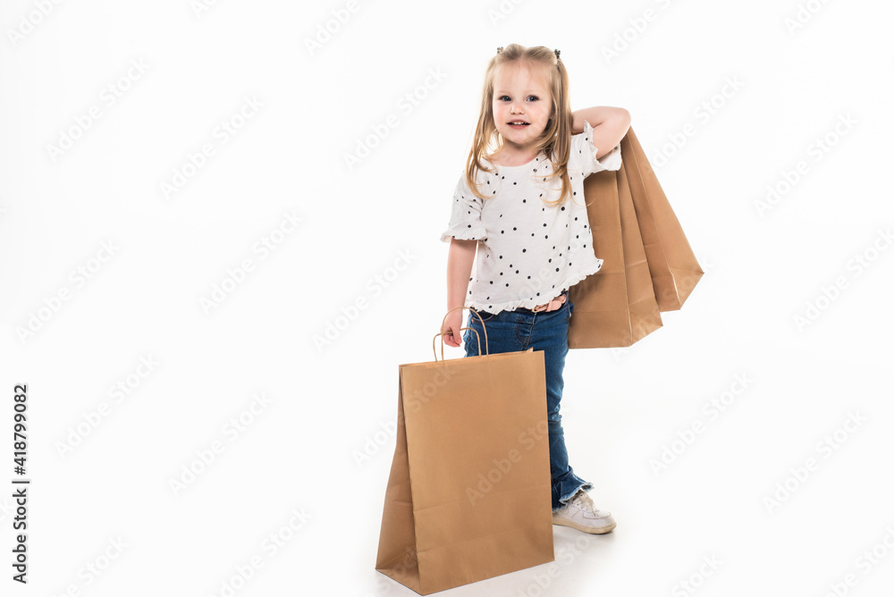 Young and joyful shopping small girl with shopping bags on white background Young and joyful shopping small girl with shopping bags on white background