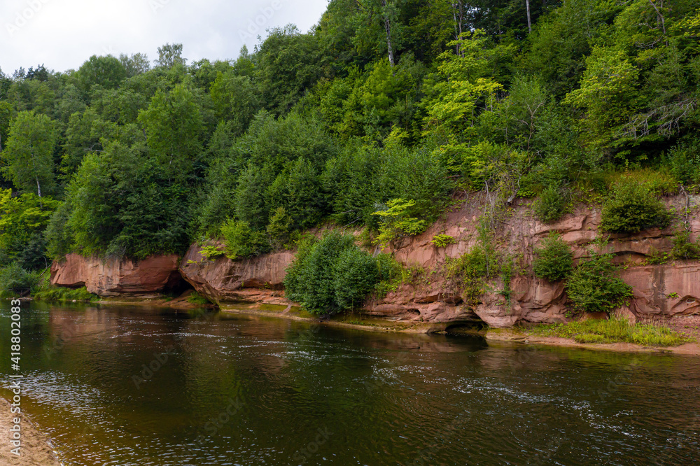 landscape with sandstone cliffs on the river bank, fast flowing and clear river water, Kuku cliffs, Gauja river, Latvia landscape with sandstone cliffs on the river bank, fast flowing and clear river water, Kuku cliffs, Gauja river, Latvia