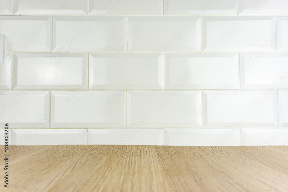 View of a wooden table with the background of white ceramic tiles