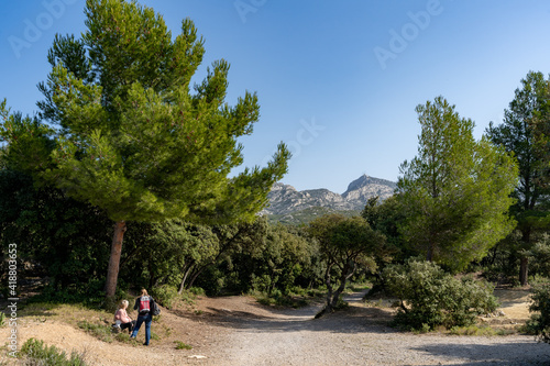 deux personnes sur un chemin de randonnée au milieu des pins méditerranéens