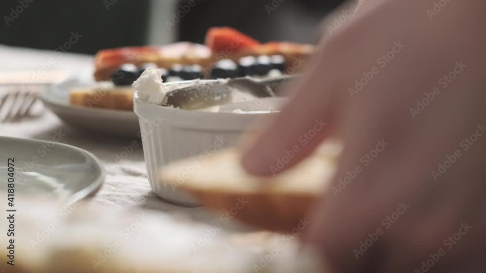 Extreme close up hands girl or woman or chef prepares breakfast and spreads soft cheese or cream on crispy croissant. concept of delicious and hearty French breakfast in the morning. Extreme close up hands girl or woman or chef prepares breakfast and spreads soft cheese or cream on crispy croissant. concept of delicious and hearty French breakfast in the morning.