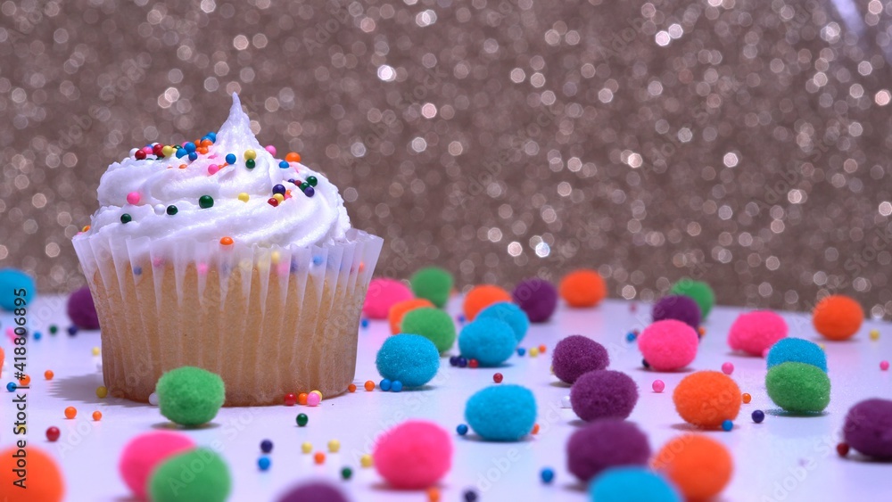 Cupcake macro shallow depth of field and decoration with sugar sprinkles. Cup cake with white vanilla cream on gold background. Process of making delicious desserts muffin for delivery or sale.