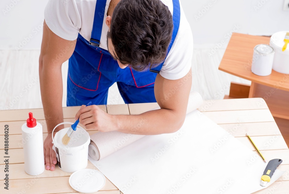 Worker working on wallpaper during refurbishment Worker working on wallpaper during refurbishment