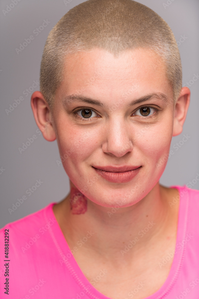 Obraz premium Young urban woman with short blond hair poses before a light colored background.
