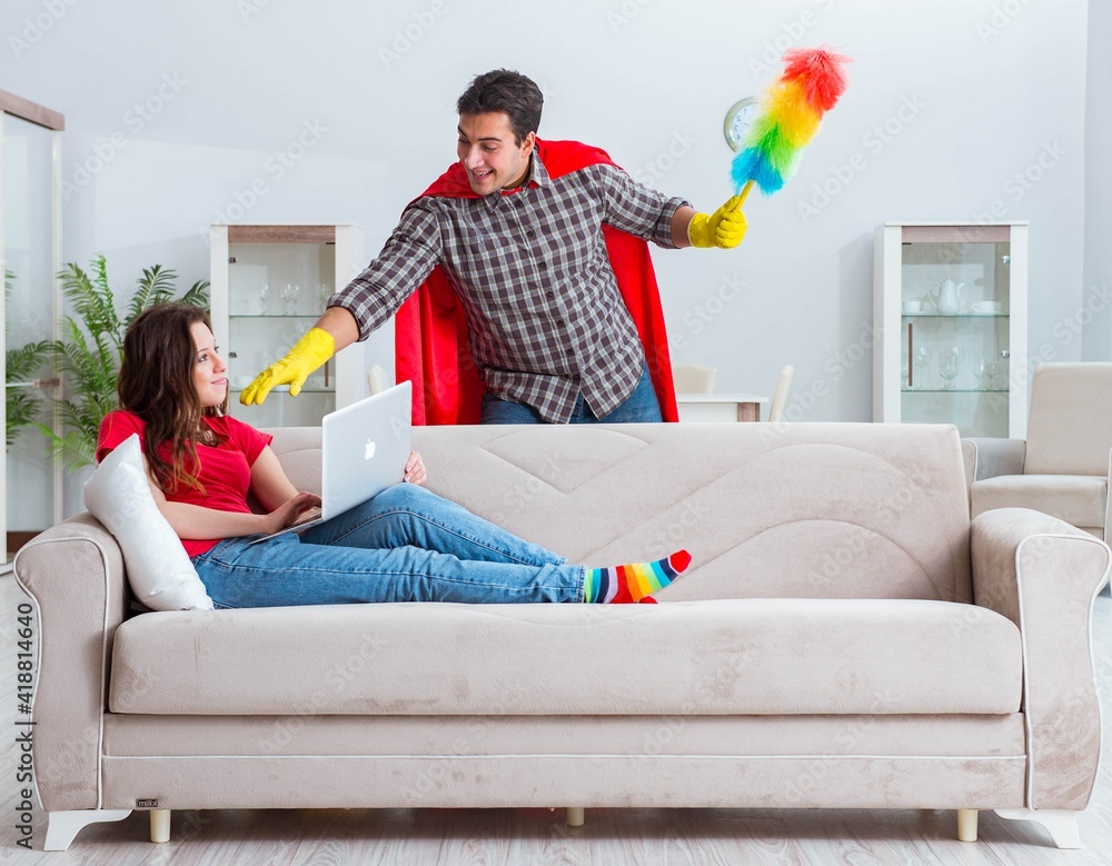 Obraz premium Superhero husband helping his wife at home