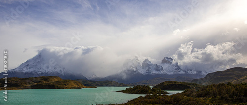 Snow-covered mountain in Patagonia Chile  with a turquoise lake in the foreground. 