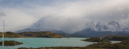 Snow-covered mountain in Patagonia Chile, with a turquoise lake in the foreground. 