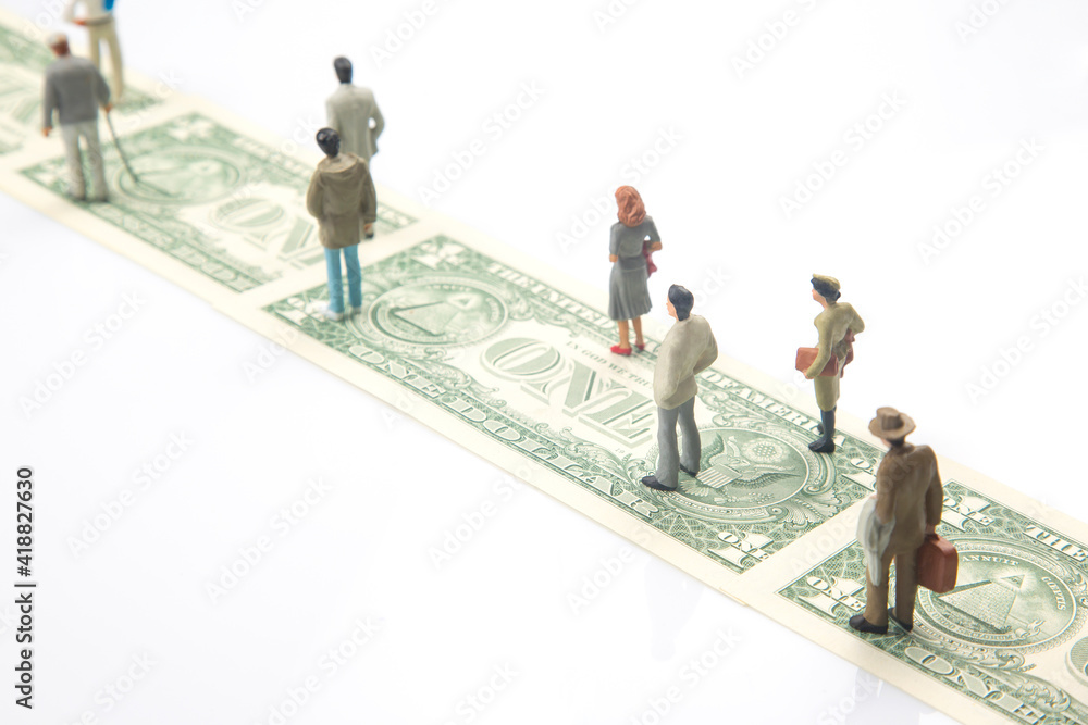 miniature people. figurines of people walk the road from dollar money to their success in life. financial independence concept miniature people. figurines of people walk the road from dollar money to their success in life. financial independence concept