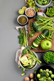 Set of various green raw healthy vegetables on wooden board