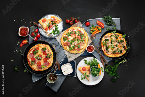Delicious fresh pizzas variety with different souces and vegetables. Homemade food concept.