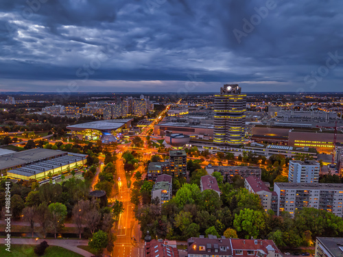 Wonderful twilight view over the illuminated Munich with business district and cars on a road from a high perspective.
