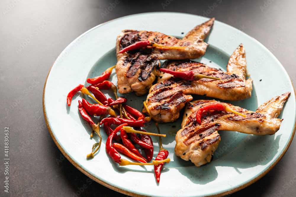 grilled chicken wings on a plate, restaurant serving, close-up top view grilled chicken wings on a plate, restaurant serving, close-up top view