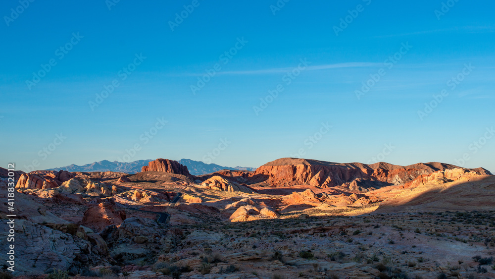 Fototapeta premium Valley of Fire State Park Ultrawide Panorama of golden hour lighting up red sandstone domes in Clark County, Nevada between Las Vegas and Zion National Park.