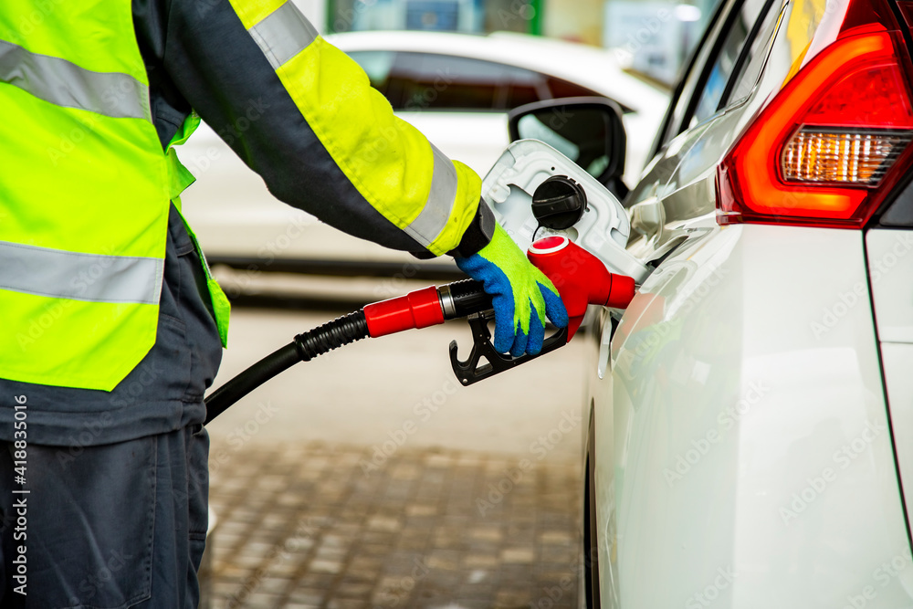 gas station employee in overalls refueling the car gas station employee in overalls refueling the car