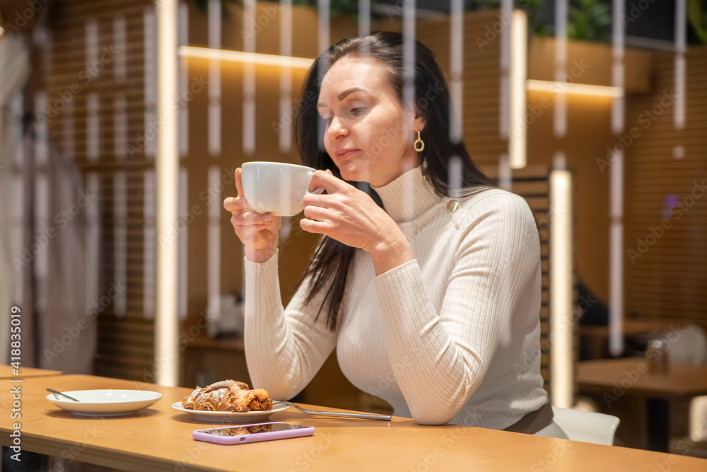 beautiful woman drinking coffee at a bar in a cafe beautiful woman drinking coffee at a bar in a cafe