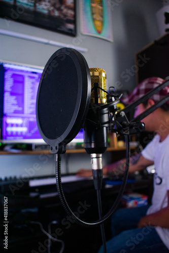 Microphone condenser with anti-pop filter in a preproduction studio at the background photo