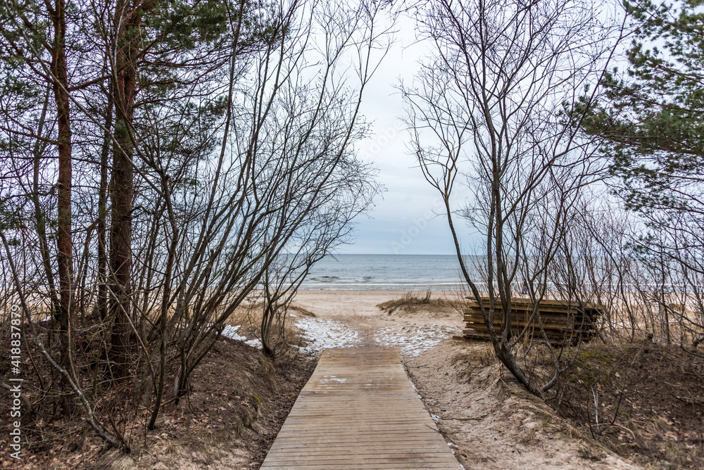 Wooden Path to a Frozen Baltic Sea Coast in Late Winter on a Cloudy Day