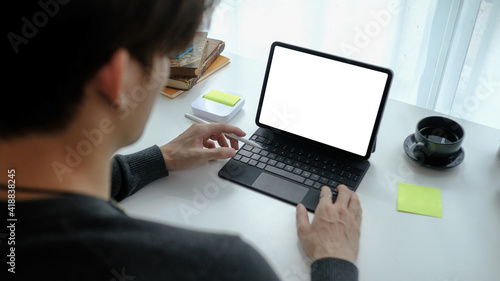 Close up view man freelancer working on computer tablet at home. © Prathankarnpap