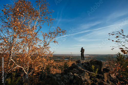 a man in nature enjoys the view and takes pictures