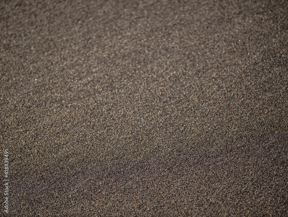 Black sand texture for background. Abstract sand pattern. Top view. Black sand beach in Bali. Copy space. Selected focus. Black sand texture for background. Abstract sand pattern. Top view. Black sand beach in Bali. Copy space. Selected focus.
