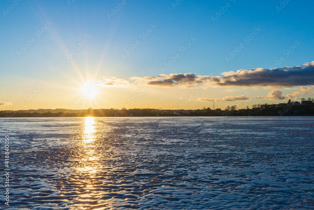 Beautiful winter landscape with frozen lake and sunrise sky. Composition of nature