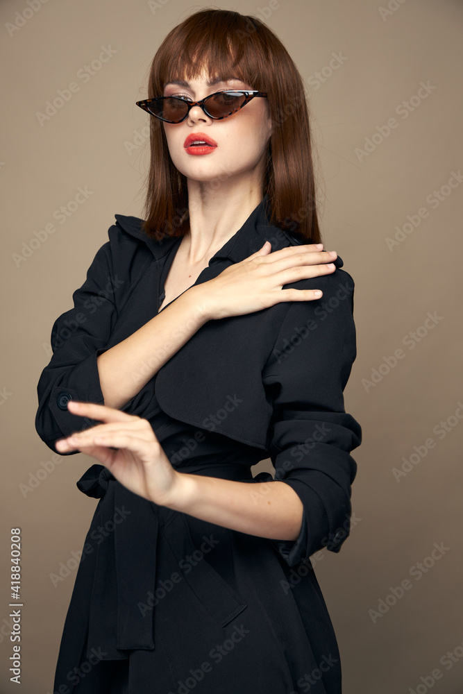 Brunette in a black coat touches his shoulder dark glasses beige Brunette in a black coat touches his shoulder dark glasses beige