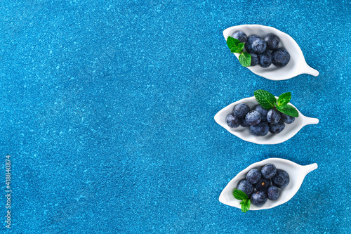 Blueberries, bog whortleberry, great biberry on a blue background. Top view. photo