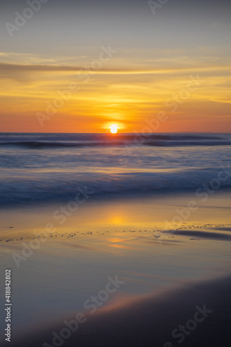 Sunset and beach. Seascape background. Bright sunlight. Sun at horizon line. Scenic view. Sunset golden hour. Sunlight reflection in water. Magnificent scenery. Copy space. Bali