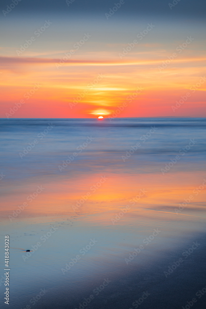 Fototapeta premium Sunset and beach. Seascape background. Bright sunlight. Sun at horizon line. Scenic view. Colorful sky. Sunlight reflection in water. Magnificent scenery. Copy space. Bali
