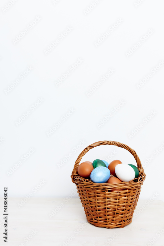 Easter eggs in a basket on a light background and church holiday Easter eggs in a basket on a light background and church holiday