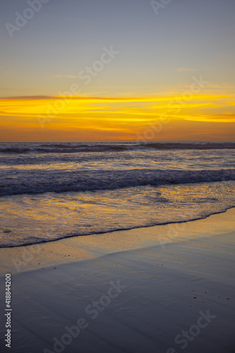 Yellow sunset on the beach. Seascape for background. Colorful sky. Beautiful water reflection. Sunlight on horizon line. Nature and environment concept. Copy space. Sunset in Bali.