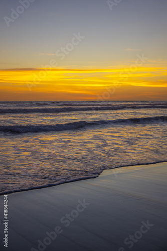 Yellow sunset on the beach. Seascape for background. Colorful sky. Beautiful water reflection. Sunlight on horizon line. Nature and environment concept. Copy space. Sunset in Bali.