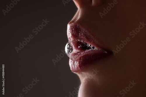 Closeup female open mouth with film of saliva. Saliva drips from erotic mouth. photo