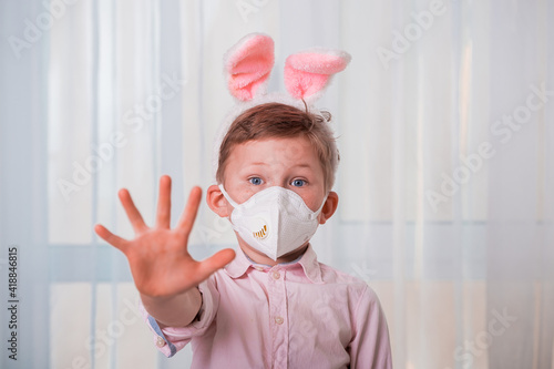 Cute funny kid on Easter egg hunt. Child boy in bunny ears wearing medicine mask. Happy Easter on quarantine coronavirus pandemic. safety social distance. spring concept © shara