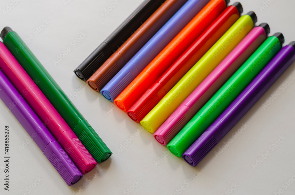 Colorful multi-colored felt-tip pens on a white background.