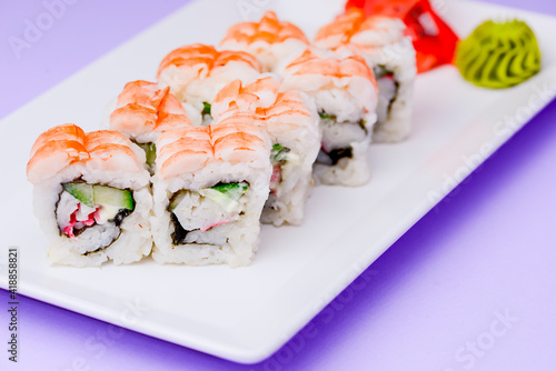 Shrimp sushi close up, Japanese cuisine. Asian cuisine concept. Served on a white plate over purple background