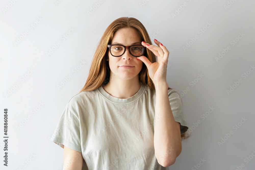 Young attractive woman with pigmentation on her face wearing glasses. Portrait of a smart confident woman.