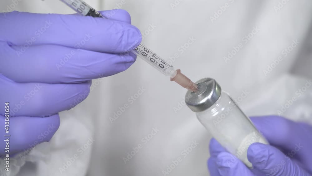 Close up doctor, nurse hands in gloves holding syringe and ampule with vaccine and prepares it for injection. vaccination. Medicine equipment. Science discovers new medicines. Health care concept 4k Close up doctor, nurse hands in gloves holding syringe and ampule with vaccine and prepares it for injection. vaccination. Medicine equipment. Science discovers new medicines. Health care concept 4k