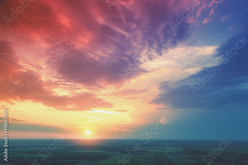 Colorful cloudy sky over the countryside at sunset. Aerial view of the countryside in the evening