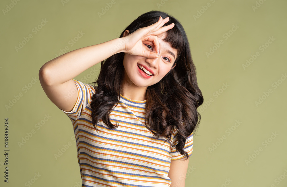Young beautiful Asian woman posing on background