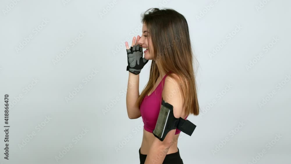 Young caucasian woman with sports clothes shouting to the lateral and announcing something over isolated background Young caucasian woman with sports clothes shouting to the lateral and announcing something over isolated background