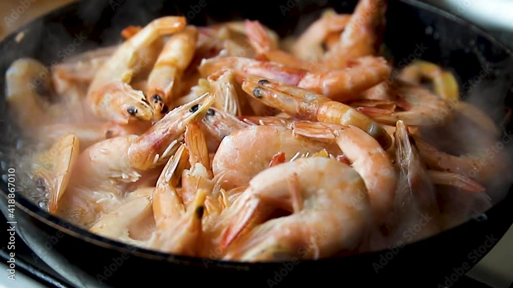 macro shot of royal frozen prawns cooking in frying pan defrosting steam comes from them macro shot of royal frozen prawns cooking in frying pan defrosting steam comes from them