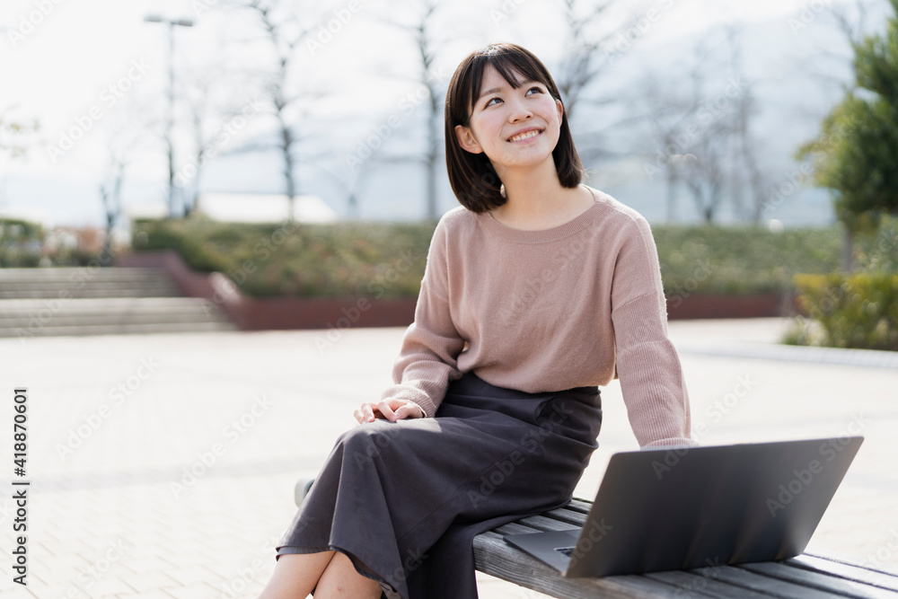 Fototapeta premium 公園でノートパソコンを使う女性