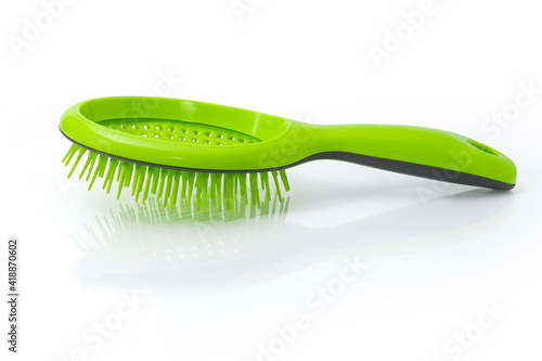 Hairbrush with plastic bristles on a white reflective surface